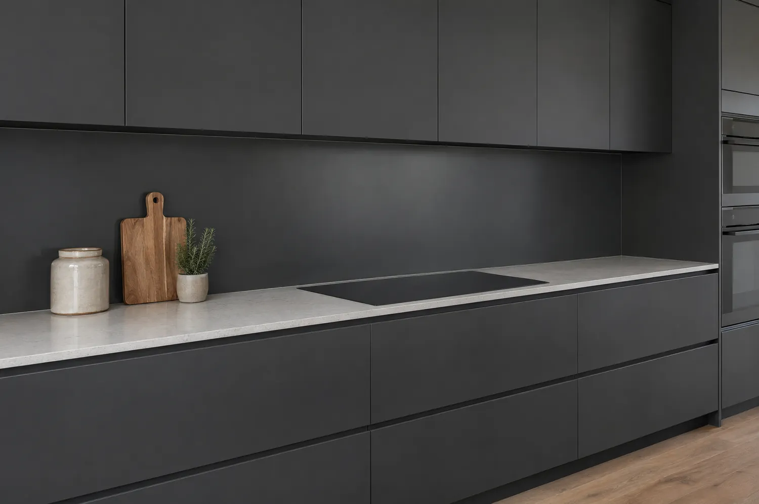 Dark kitchen with a black glass splashback and matching cabinetry